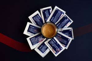 Chávena de café com os pacotes de acúçar
